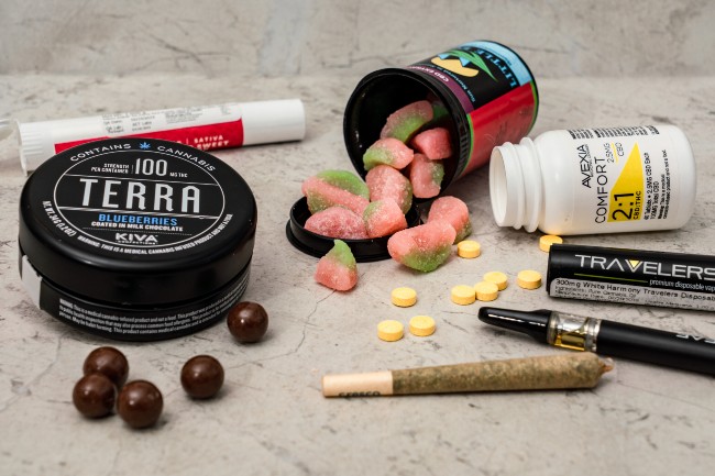 A variety of cannabis products including edibles, a vape, flower, concentrates, and pills