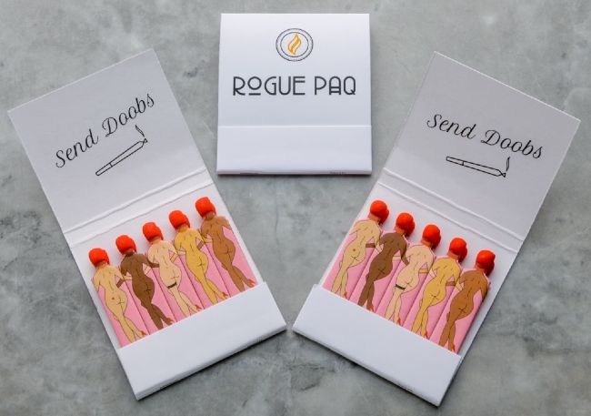 a display of Rogue Paq's matches with a white cardboard case, holding 5 matches inside with different skin toned, nude, can-can dancers with tip of their heads, bright red, being the place to strike the match