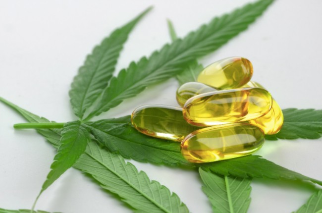 capsules next to a cannabis leaf