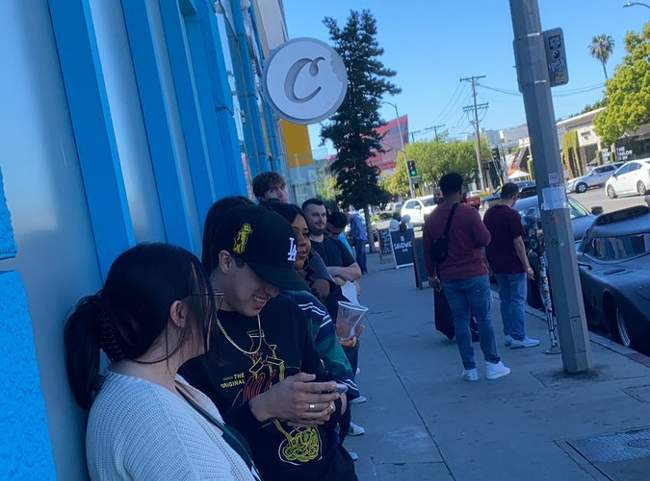 A line of people waiting outside of the Cookie's dispensary.