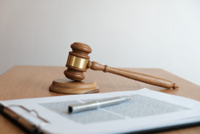 A gavel and a clipboard with papers