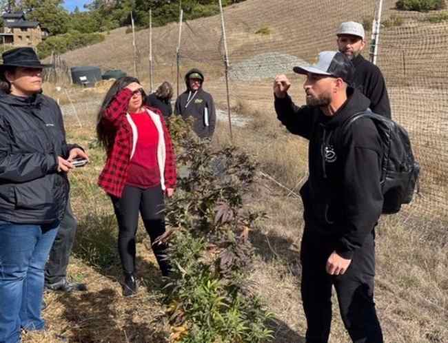 Photograph of Nikka T and a group of people in a marijuana field.