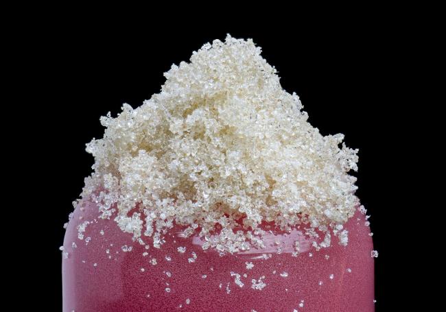 On the top of a glass blown eraser is a pile of fine micron bubble hash that is almost a clear white hue within the crystals.