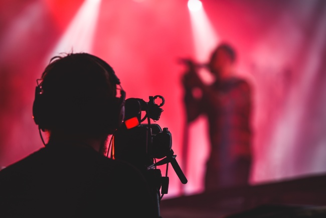 silhouette of a man filming a concert show