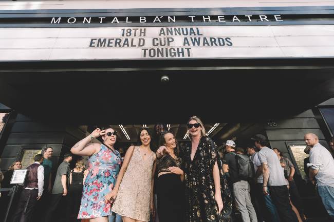 4 women standing under the Montalban Theatre marquee with the words reading 18th Annual Emerald Cup Awards Tonight