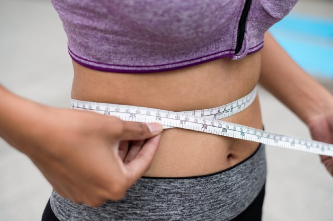 A woman measuring her waist