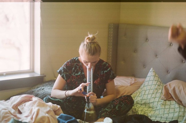 Someone lighting up a bong and smoking out of it