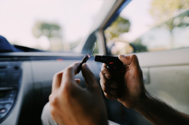 Someone lighting up a joint in their car to hotbox